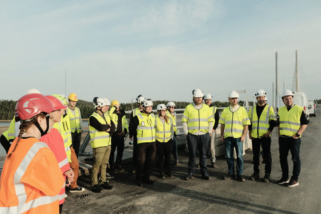 Participants in safety vests visiting a bridge construction site.